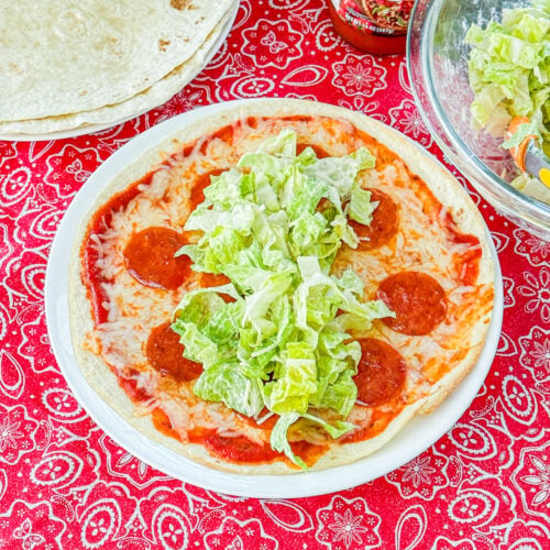 Pizza salad wrap with romaine, pepperoni, cheese, and pizza sauce before rolling up