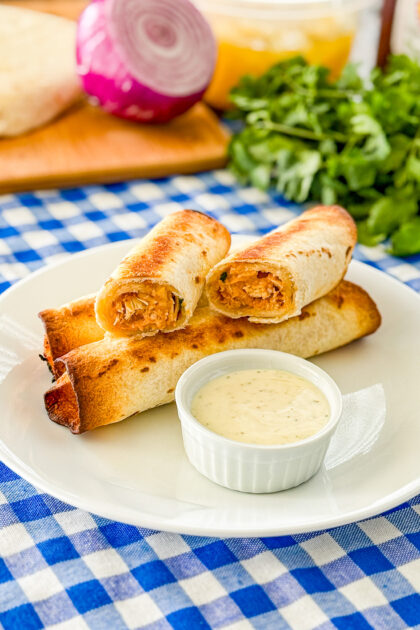 BBQ chicken flautas served on a plate with dipping sauce