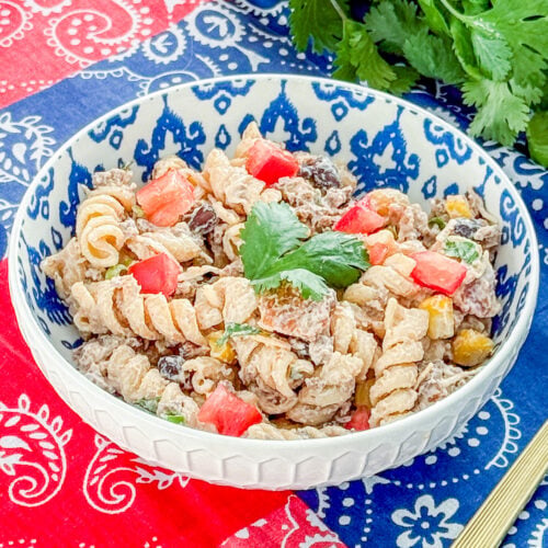 Healthy cowboy pasta salad with protein pasta, beef, bacon, corn, black beans, cilantro, and green onion