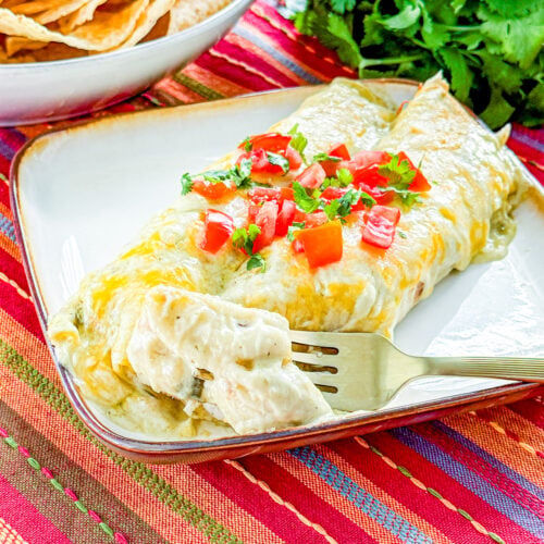 Chicken enchilada showing creamy chicken, cream cheese, and green chile filling