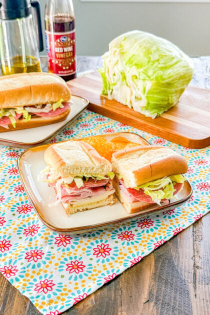 Italian sub sandwich cut in half to show layers of meat, cheese, and lettuce