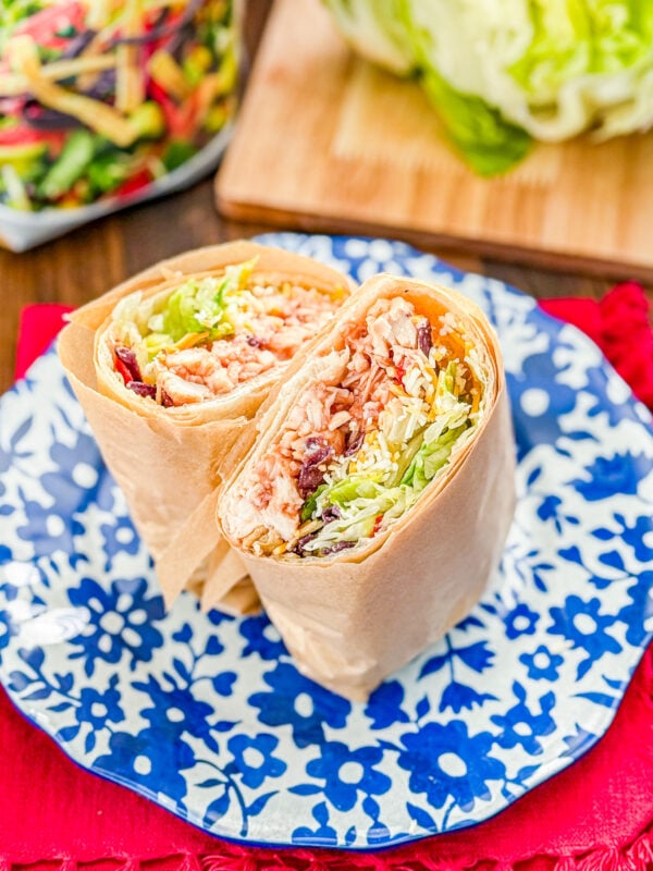 Close-up of a sliced Whiskey River chicken wrap with barbecue chicken and crispy tortilla strips