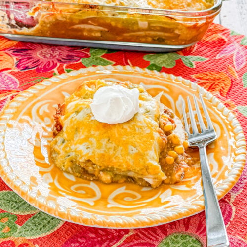 Close-up of cheesy chicken taco casserole with green chilies, corn, and refried beans