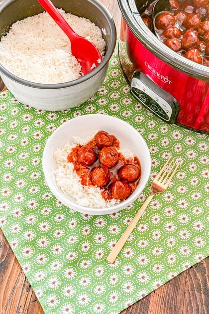 Bowl of crockpot cola meatballs with barbecue sauce over rice