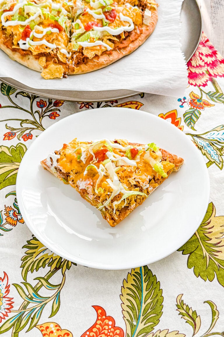 Easy Loaded Taco Pizza with ground beef, refried beans, cheese, lettuce, sour cream, and salsa