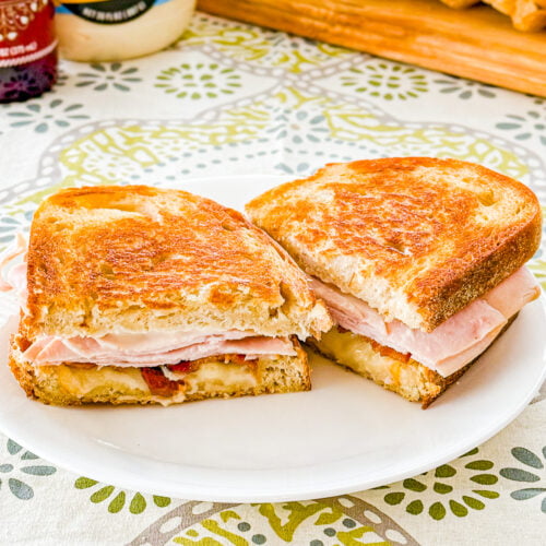 Close-up of a grilled turkey bacon melt with melted Monterey Jack cheese and tomato