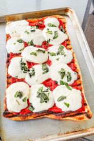 Grilled Margherita pizza topped with marinara, fresh mozzarella, and basil