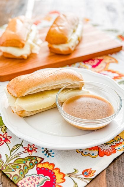 Close-up of a turkey French dip sandwich with melted provolone cheese on a toasted roll
