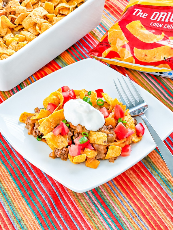 Close-up of baked Frito pie with cheesy ground beef, beans, and corn chips