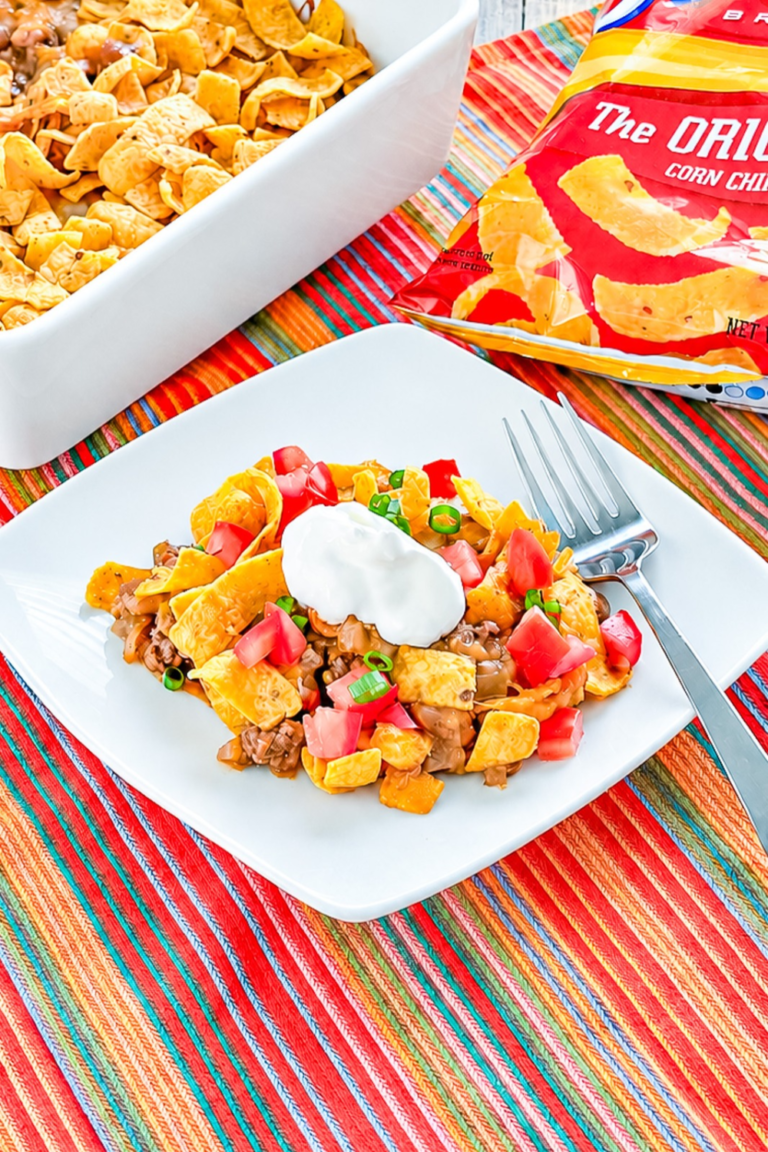 Close-up of baked Frito pie with cheesy ground beef, beans, and corn chips