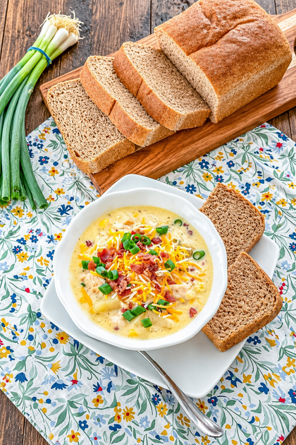 Bowl of Crock Pot Chicken Corn Chowder topped with bacon, cheddar cheese, and green onions