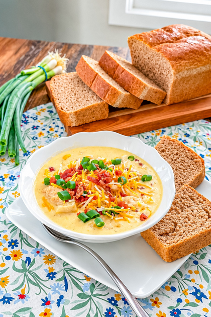 Chicken corn chowder topped with bacon crumbles, shredded cheddar, and sliced green onions