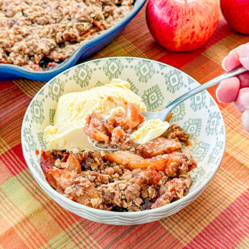 Spoonful of smoked apple crisp with cinnamon apples and buttery crumble